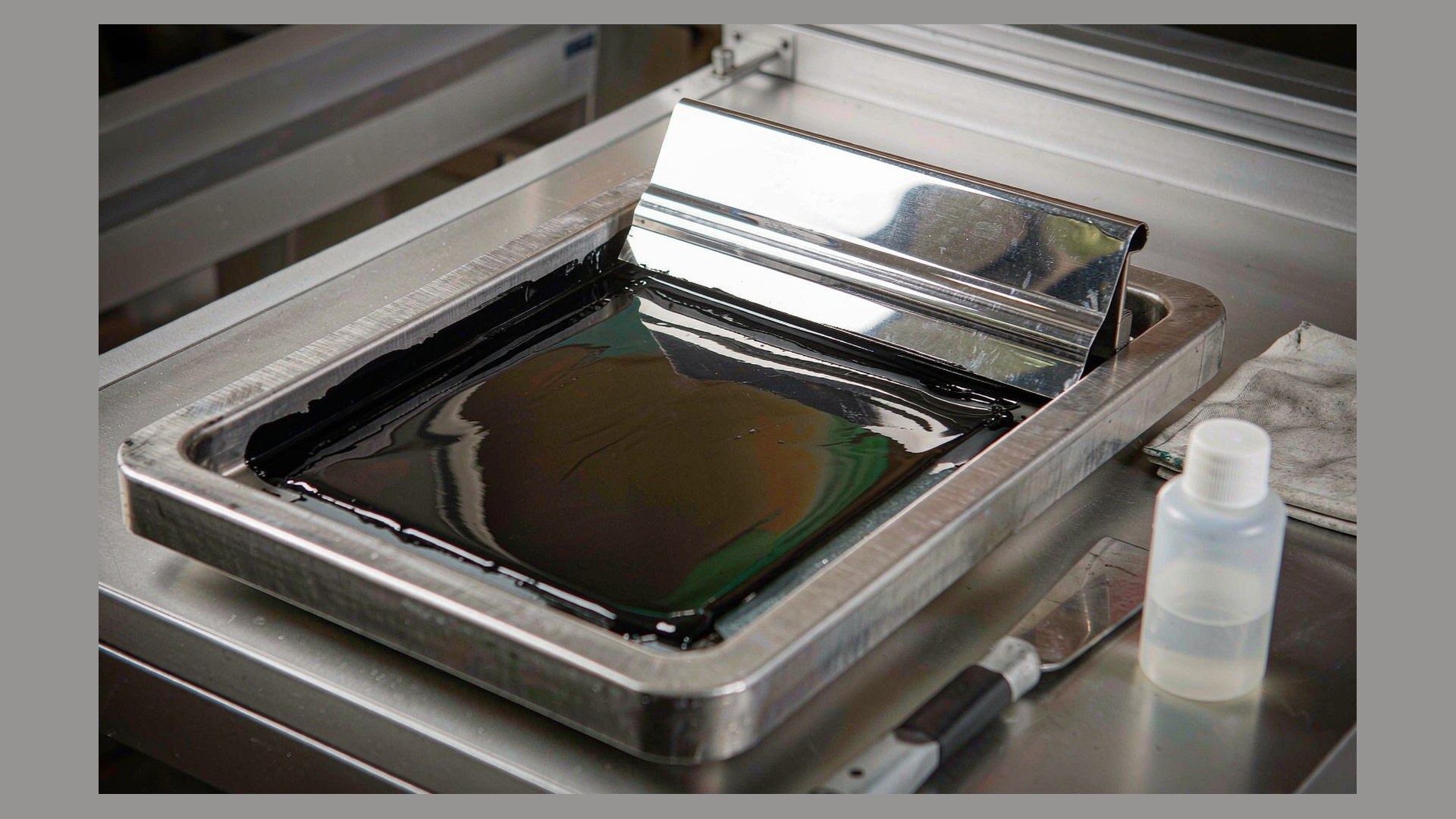 Open ink tray with pad printing ink and a doctor blade during cleaning and ink viscosity control
