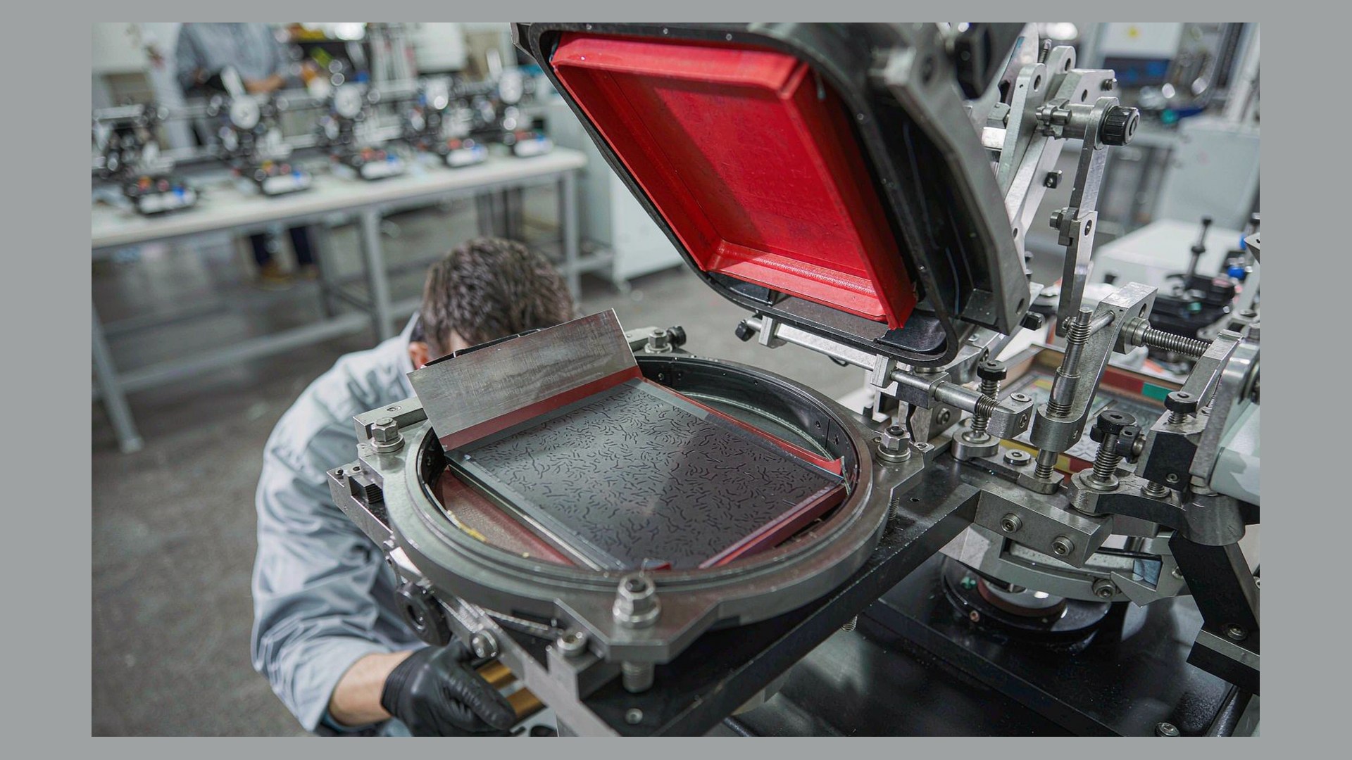Technician checking the ink tray and doctor blade of an open tray pad printer during a maintenance check